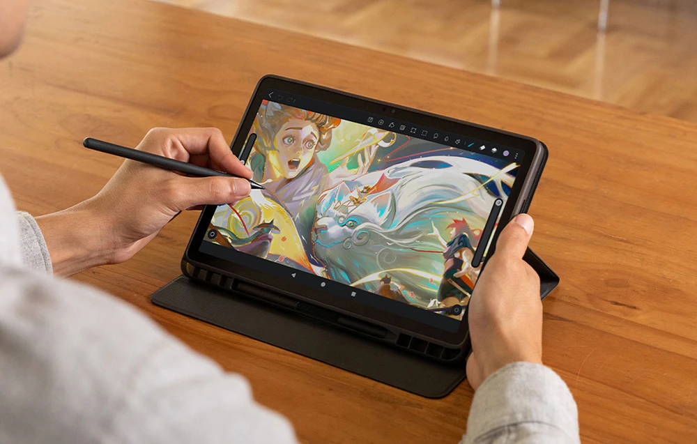 Mâini desenând o ilustrație fantastică colorată cu personaje pe o tabletă cu un stylus, vedere de sus