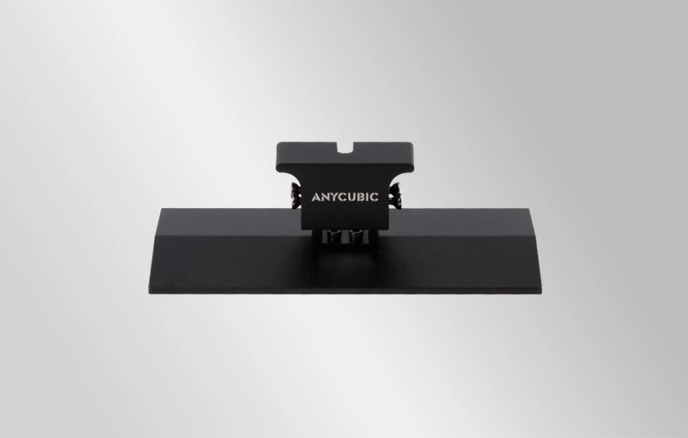 Placă de imprimare Anycubic neagră, cu o suprafață netedă și plană și un mâner de montare în partea superioară.