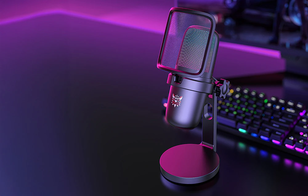 Microfon de gaming Onikuma negru pe birou, tastatură și monitor în depărtare