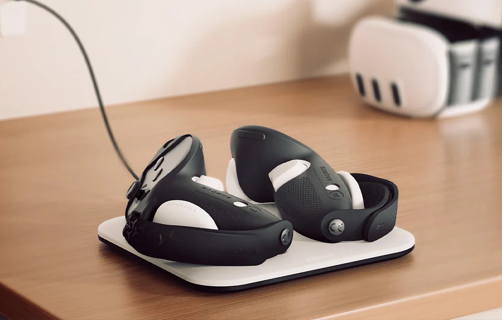 Stația BoboVR CD3 cu două controlere VR încărcate prin cablu pe o masă din lemn