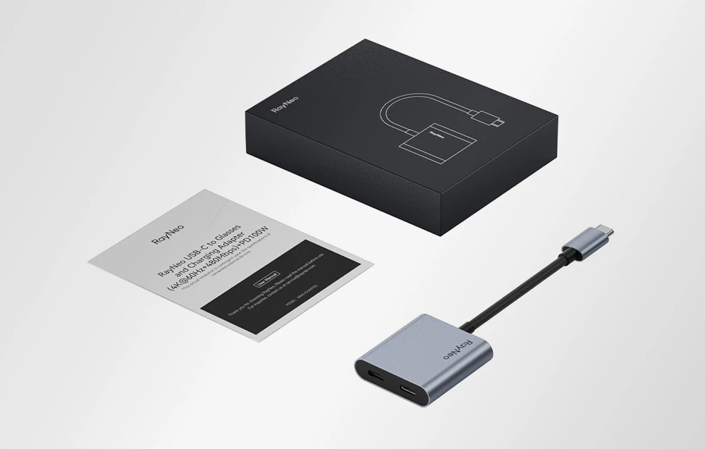 Adaptor RayNeo USB-C cu cablu și instrucțiuni lângă ambalaj, prezentat în fundal luminos.