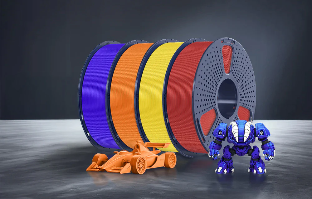 Patru bobine cu filament albastru, portocaliu, galben și roșu lângă o mașină portocalie și un robot albastru.