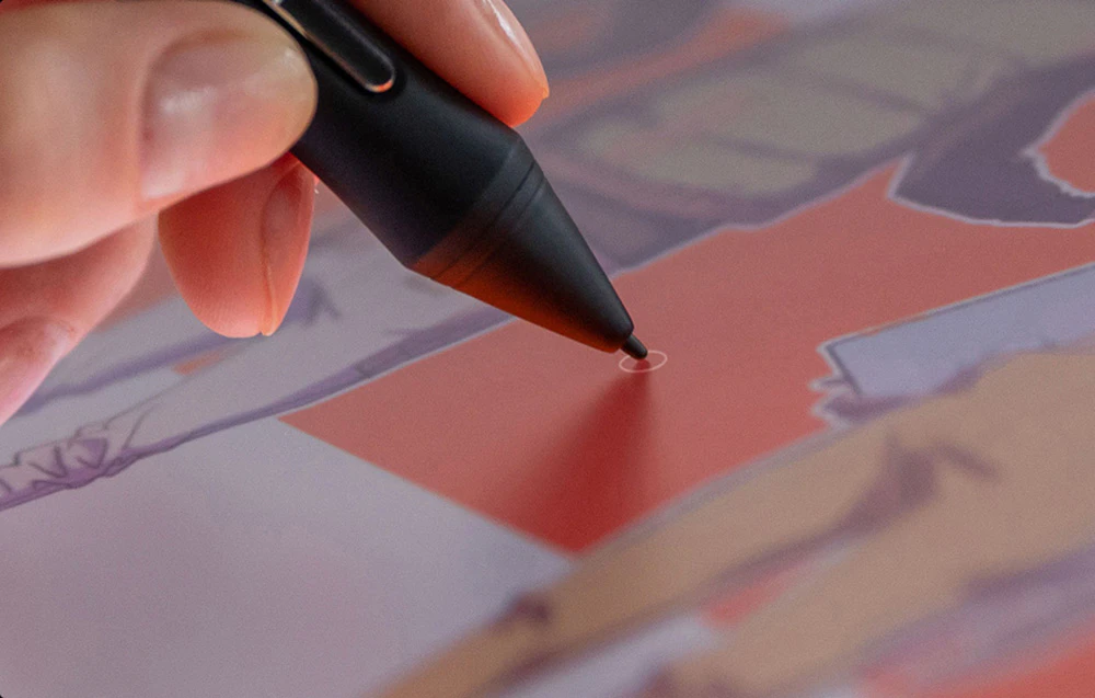 O mână care ține un stylus Huion negru atinge suprafața tabletei în timp ce creează o ilustrație digitală