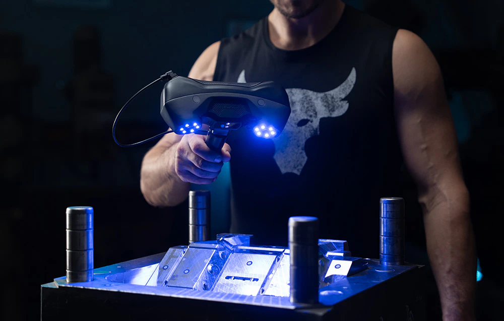Prim plan al scanerului 3D în timp ce lucrează la o matriță industrială din metal