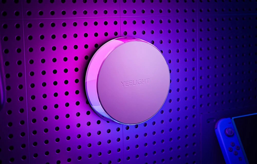 Prim plan al luminii de noapte Yeelight Vega montată pe un perete perforat, iluminată cu lumină violet.