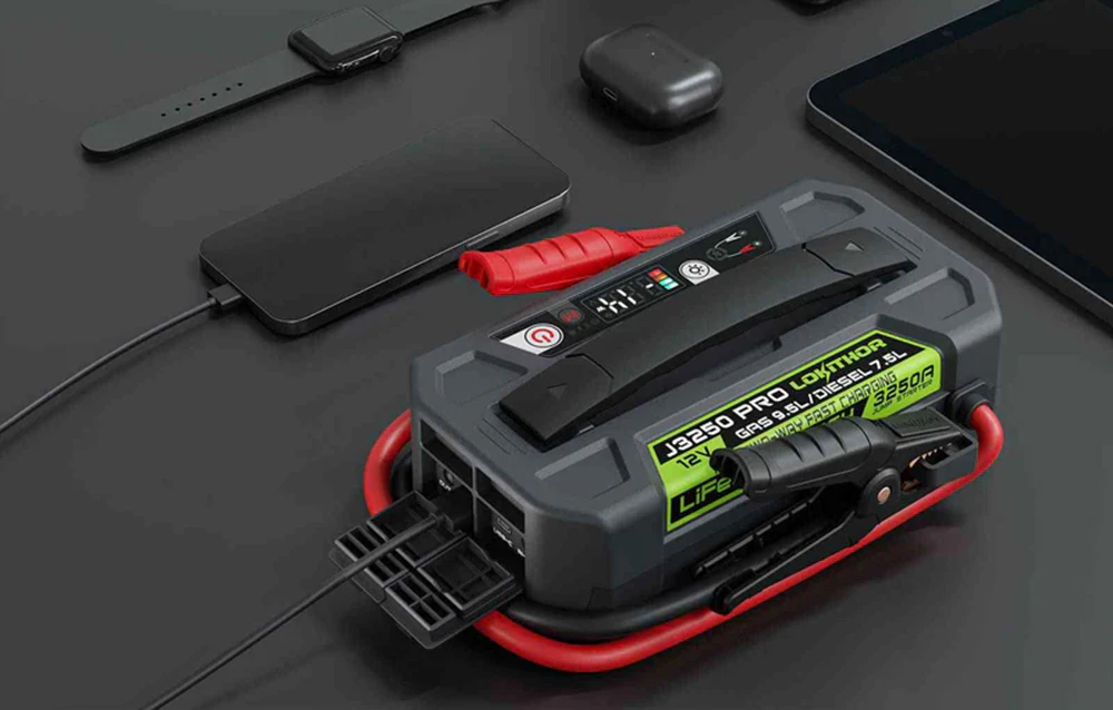 Lokithor J3250 Pro folosit ca power bank pentru încărcarea unui smartphone lângă căști și o tabletă pe un birou.