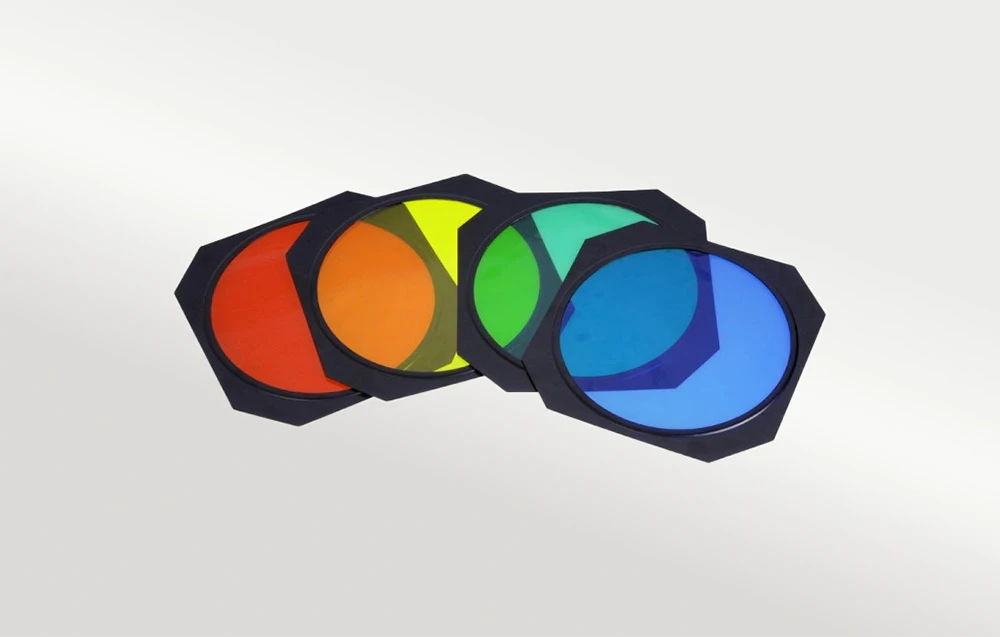 Patru filtre rotunde colorate pentru lampă, în roșu, galben, verde și albastru.