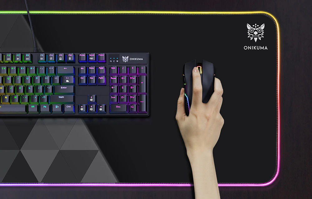 Mousepad de gaming Onikuma MP006 în utilizare pe birou. Pe mousepad sunt așezate o tastatură și un mouse, pe care cineva le folosește.