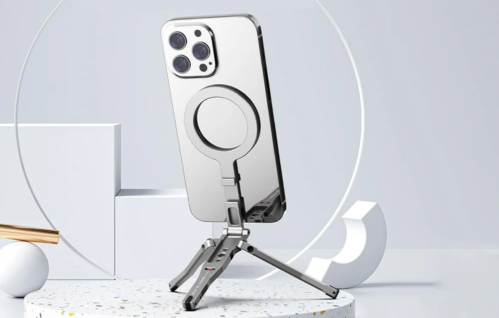 iPhone pe un suport pe o suprafață albă cu decorațiuni geometrice