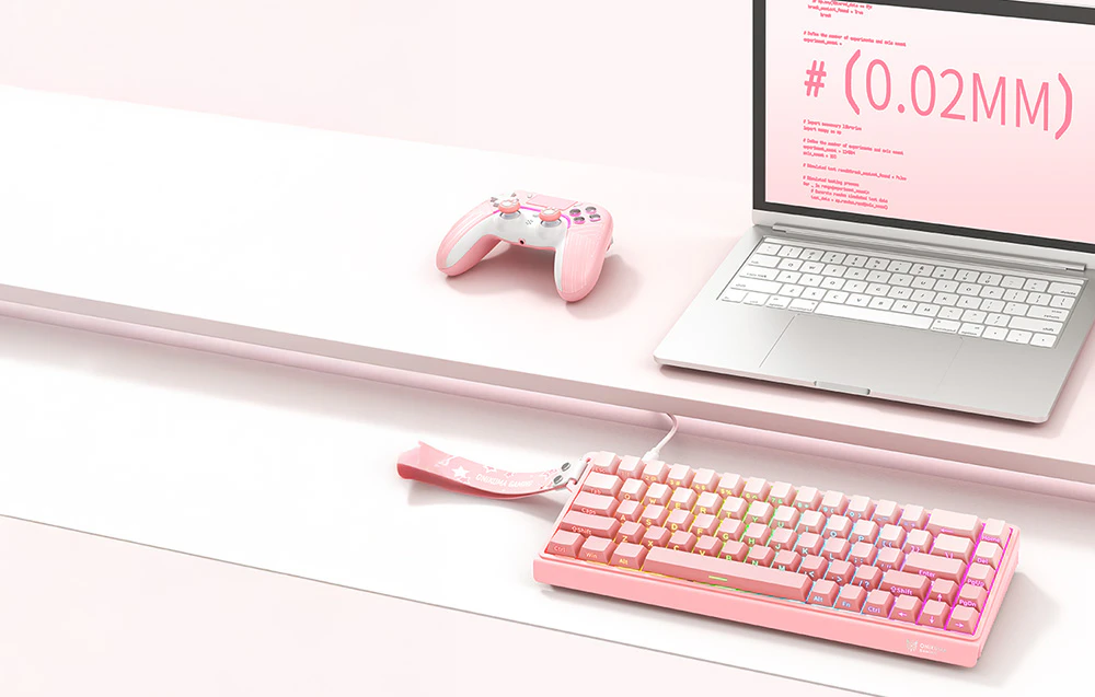 Tastatura roz Onikuma pe birou lângă laptop și pad de gaming