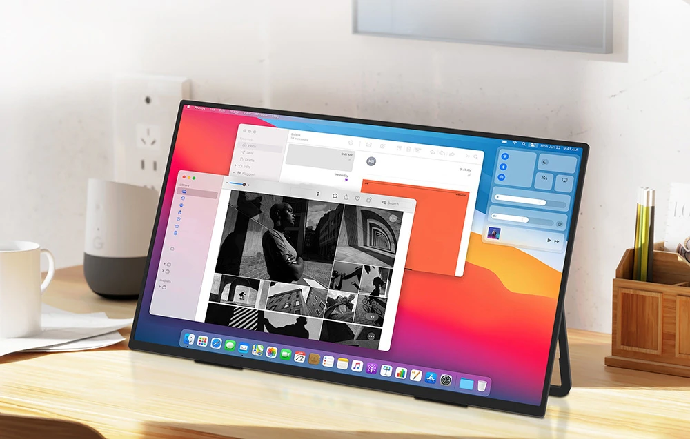 Un monitor portabil care rulează macOS și afișează o galerie foto și un panou de control pe un birou din lemn