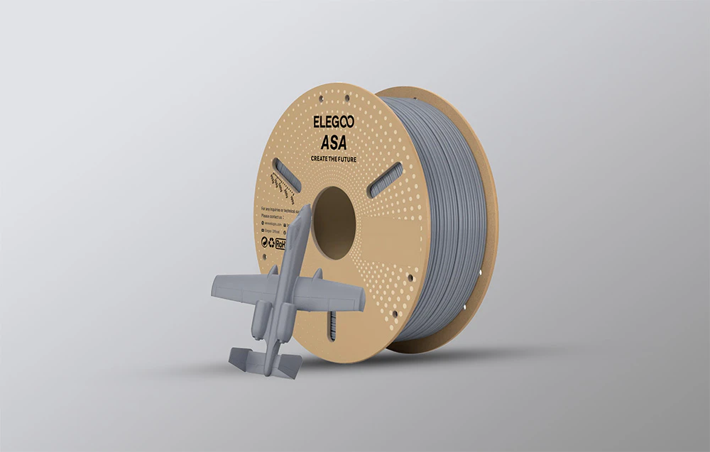Filament gri lângă un model de avion imprimat 3D