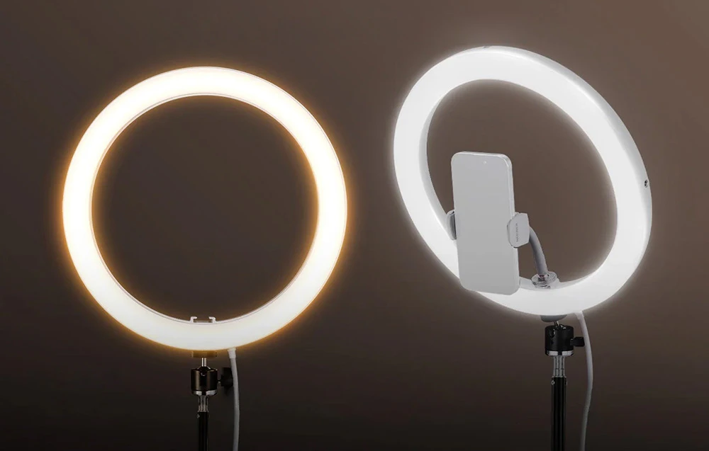 O comparație între două inele luminoase cu LED-uri, care prezintă o lumină de culoare caldă în stânga și o lumină albă rece, cu un suport pentru telefon, în dreapta.