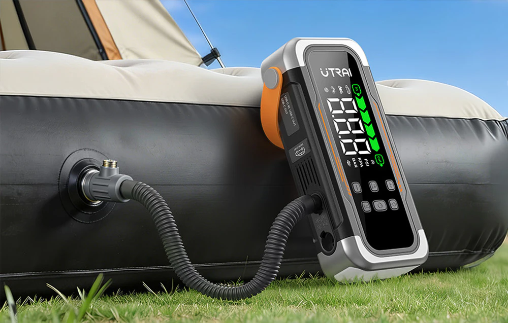 Un demaror auto pompează aer într-un saltea de camping alb-negru.