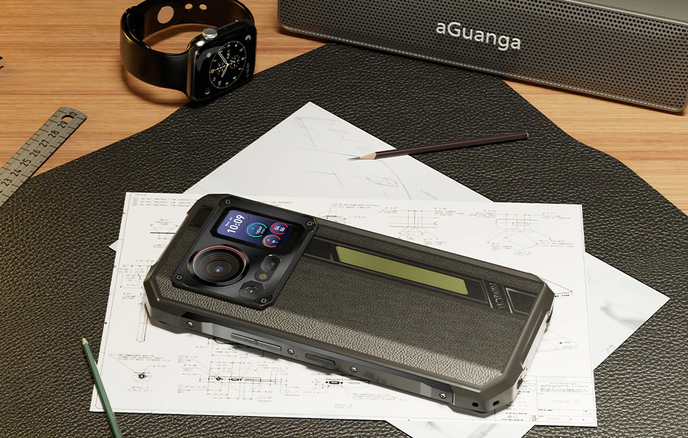 Un smartphone robust așezat pe planuri arhitecturale lângă un creion, un ceas inteligent și un difuzor wireless.