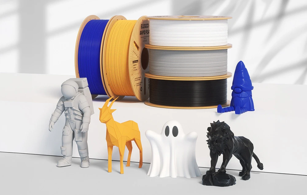 Bobine colorate de filament ELEGOO RAPID PLA stau în spatele figurinelor unui astronaut, unei capre, unui fantomă, unui leu și unui gnom pe un fundal deschis