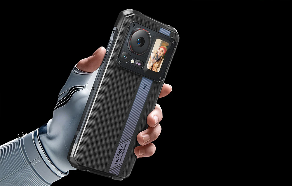 O mână în mănușă albă ținând un smartphone cu o previzualizare a fotografiei (selfie) afișată pe ecranul din spate.