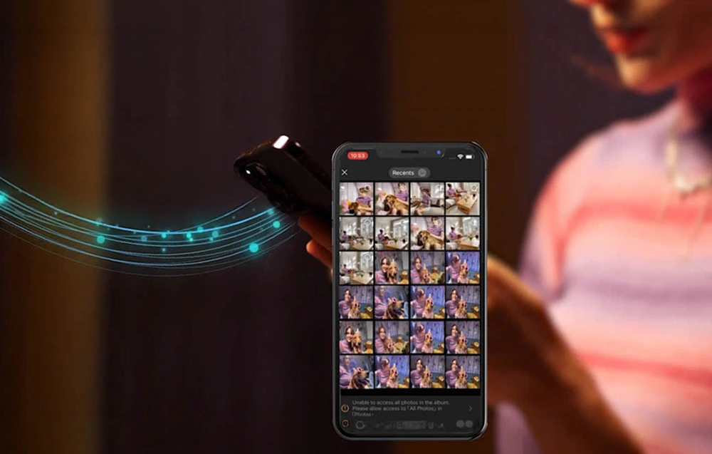 O persoană ține în mână un smartphone pe care se afișează o galerie foto, iar în apropiere se vede o imagine care simbolizează transferul wireless de date