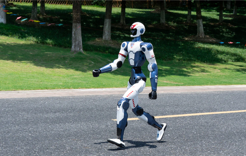 Un robot umanoid mărșăluind pe o alee asfaltată într-un parc într-o zi însorită
