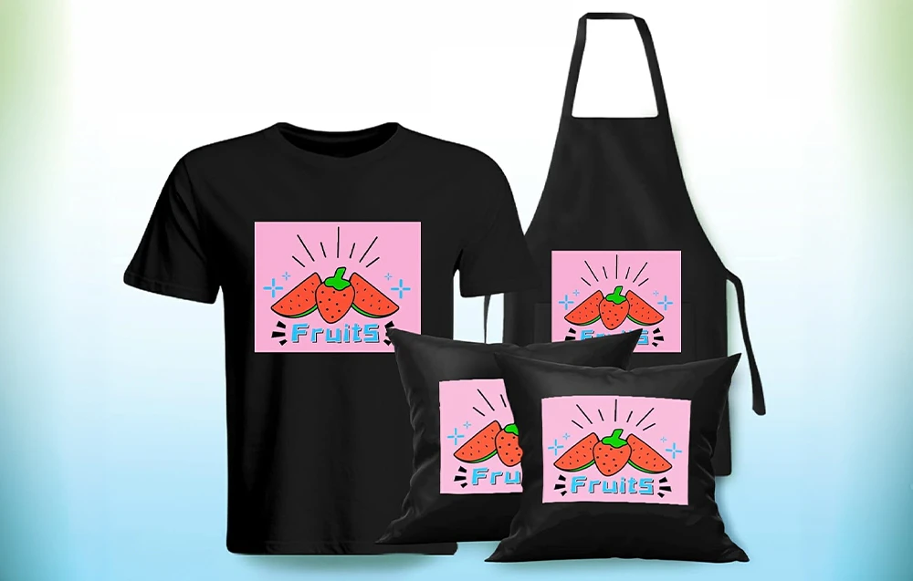 Un tricou negru, un șorț și două perne cu un imprimeu roz reprezentând căpșuni, pepeni verzi și cuvântul „Fruits”.