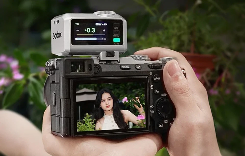 Un mini-blitz Godox iT30Pro S argintiu montat pe un aparat foto în timpul realizării unei fotografii