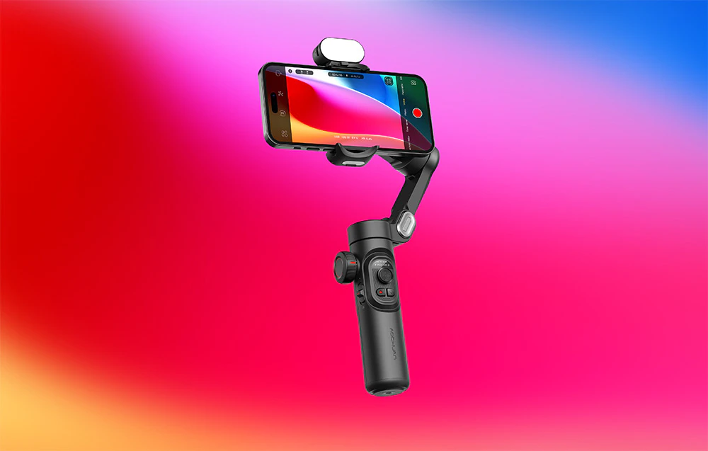 Un gimbal cu un smartphone în modul de înregistrare, prezentat pe un fundal cu gradient roz-albastru.
