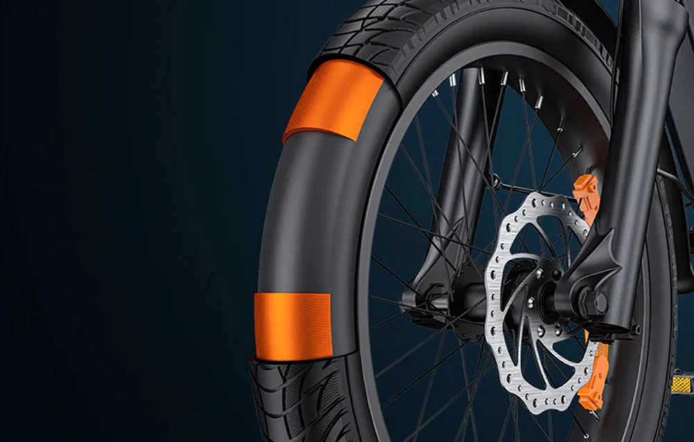 Prim-plan al roții din față a unei biciclete electrice cu anvelopă lată și elemente reflectorizante portocalii