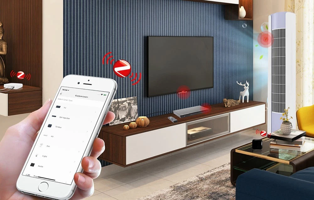 O mână ținând un smartphone cu o listă de dispozitive Custom Learn pe fundalul unui living cu televizor, media player și aparat de aer condiționat