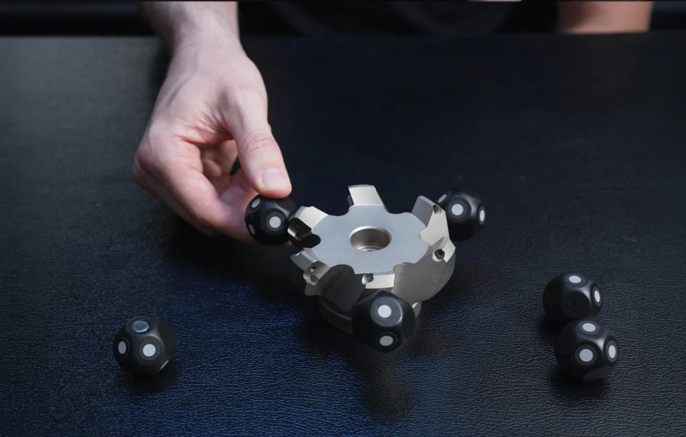 O mână așează un marcaj negru pe o carcasă metalică plată