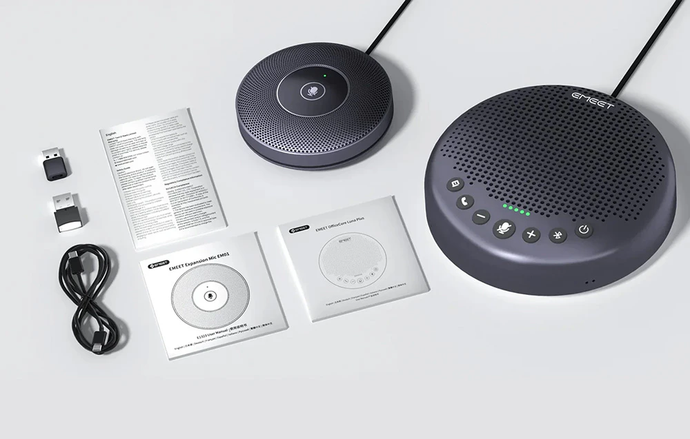 Un kit pe fundal alb conținând un difuzor de conferință, un microfon extern mai mic, cabluri, receptoare USB și manuale de utilizare.