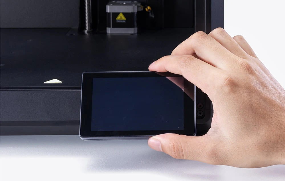 O mână atingând ecranul de control al imprimantei 3D