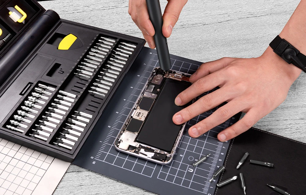 Repararea interiorului unui smartphone cu ajutorul unei șurubelnițe electrice și a unui set de biți.