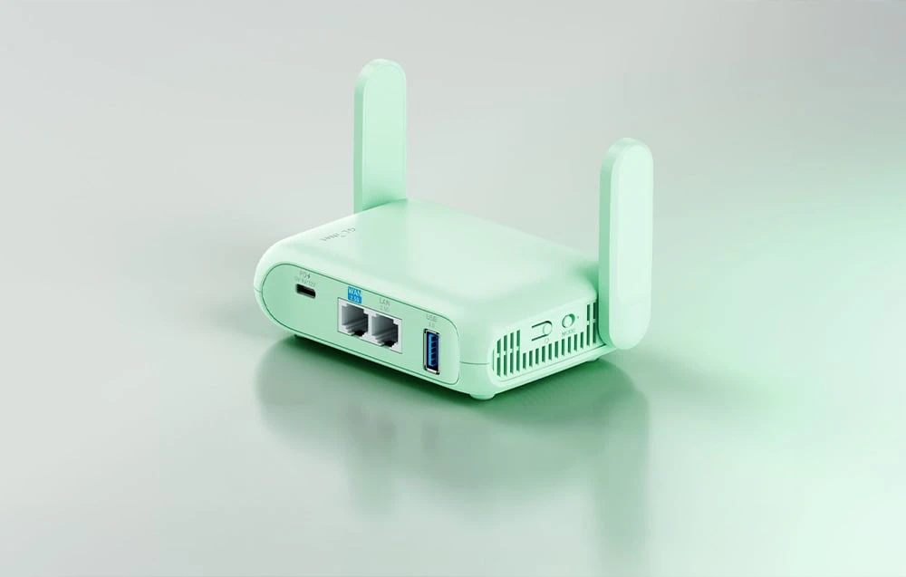 Un router GL.iNet verde se află pe o masă de culoare deschisă