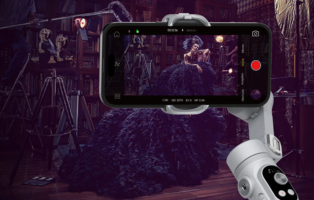 Un gimbal cu un smartphone care înregistrează o ședință foto elegantă într-un studio atmosferic cu decor vintage.