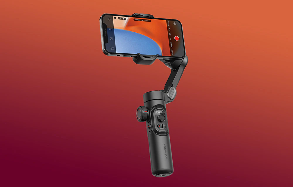 Un gimbal cu un smartphone în modul de înregistrare prezentat pe un fundal cu gradient roșu-portocaliu.