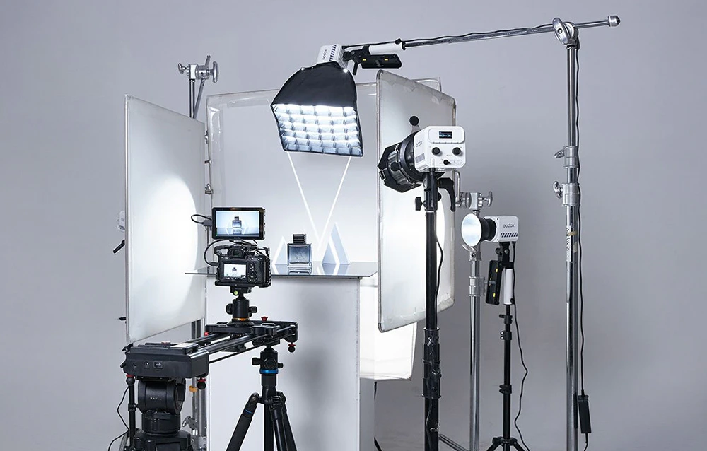 Set profesional de iluminat de studio Godox cu trepiede, lămpi, softboxuri și difuzoare pe un fundal luminos