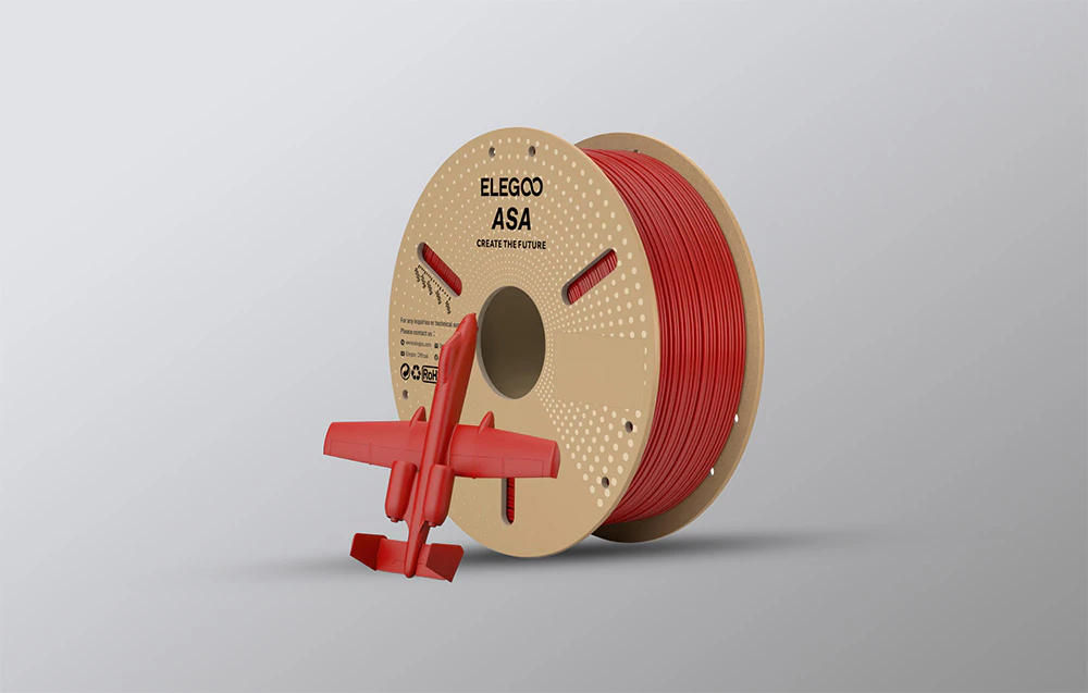 Filament roșu lângă un model de avion imprimat 3D