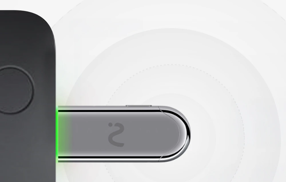 O lumină verde emană din dispozitivul metalic alungit cu simbolul unei unde, conectat la partea laterală a computerului.