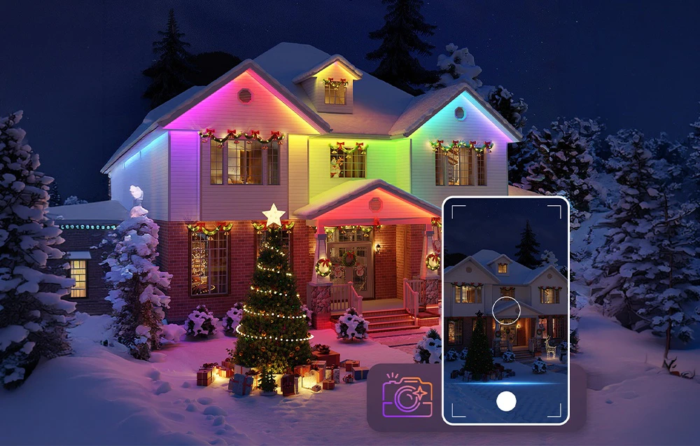Un brad de Crăciun și o casă cu iluminare LED colorată într-un decor înzăpezit, controlate de un smartphone.