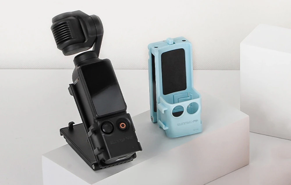 Camera DJI Pocket montată în suportul Sunnylife negru, lângă versiunea albastră goală a suportului