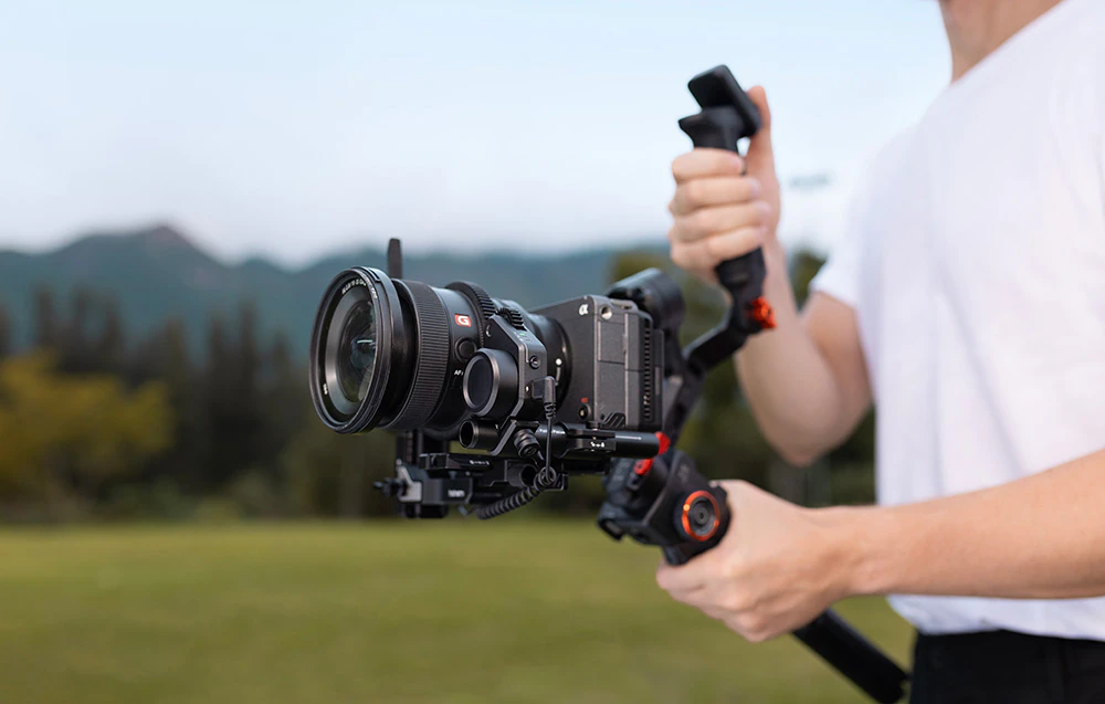 Un băiat ținând un gimbal cu o cameră montată