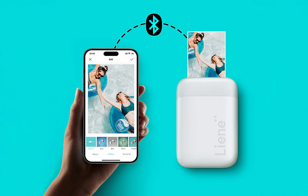 Mână ținând un smartphone lângă o imprimantă foto portabilă, conectată la aceasta prin Bluetooth