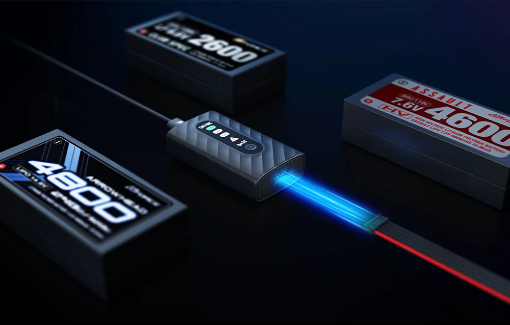 Încărcător SkyRC Type35 conectat la un pachet LiPo lângă mai multe baterii.