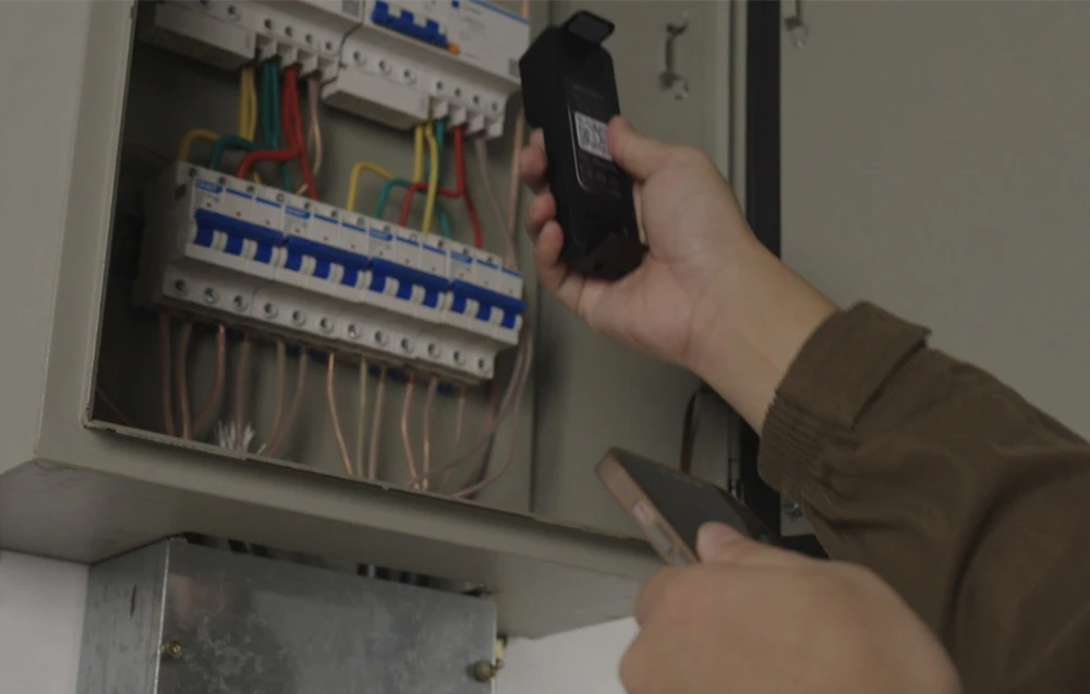 O cameră de imagistică termică îndreptată spre o cutie electrică deschisă cu siguranțe.