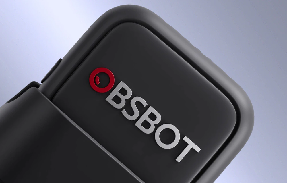 Prim-plan al colțului rotunjit al unui microfon OBSBOT cu un logo roșu clar vizibil pe o carcasă neagră mată