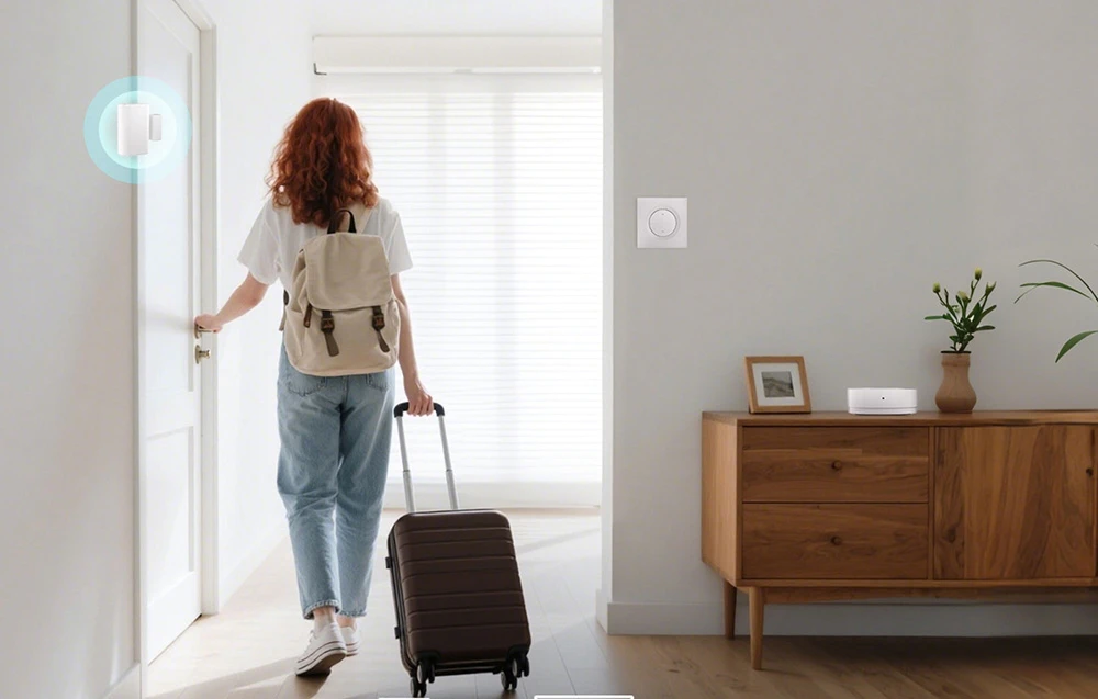 O femeie cu un rucsac pe spate și o valiză pe roți părăsește apartamentul. Pe perete, un întrerupător inteligent deasupra comodei.