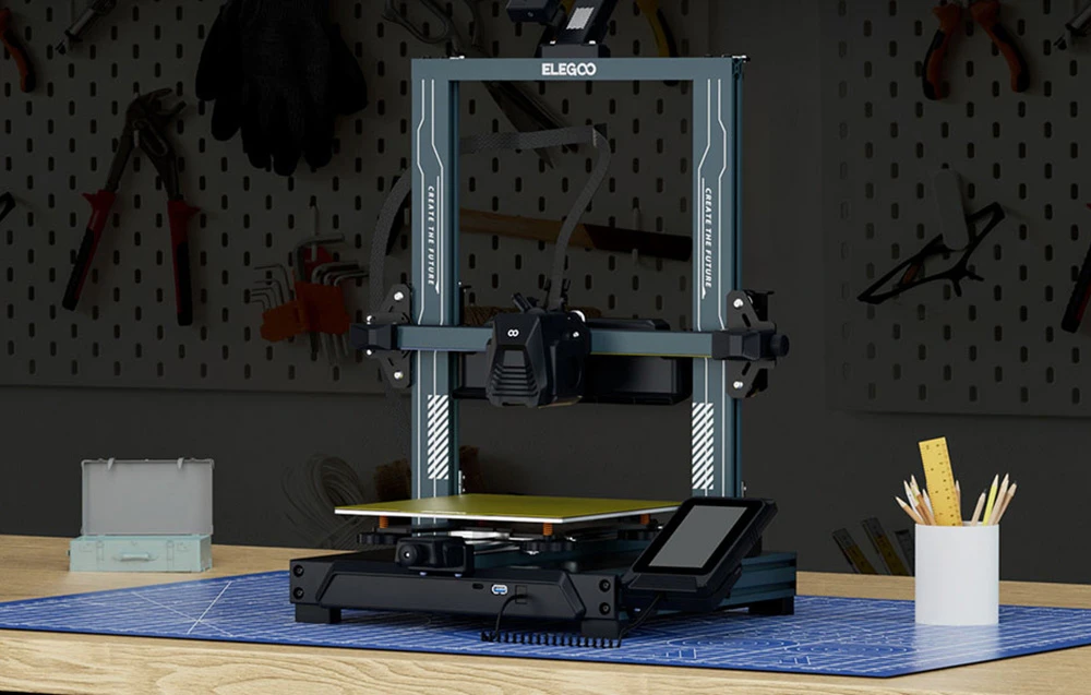 Imprimantă 3D ELEGOO așezată pe o masă în atelier cu unelte în fundal