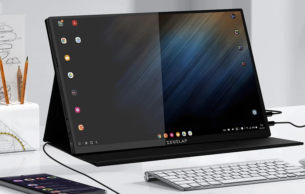 Monitorul portabil ZEUSLAP așezat pe un birou lângă o tastatură și un smartphone