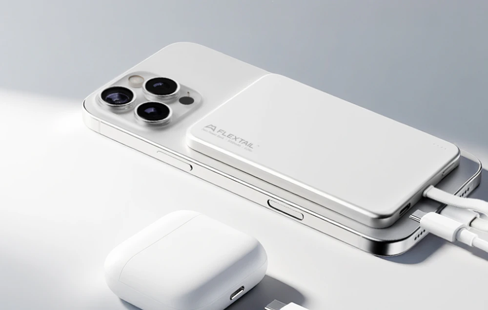 Bateria externă FlexTail încărcând un smartphone și o carcasă pentru căști prin cabluri USB.