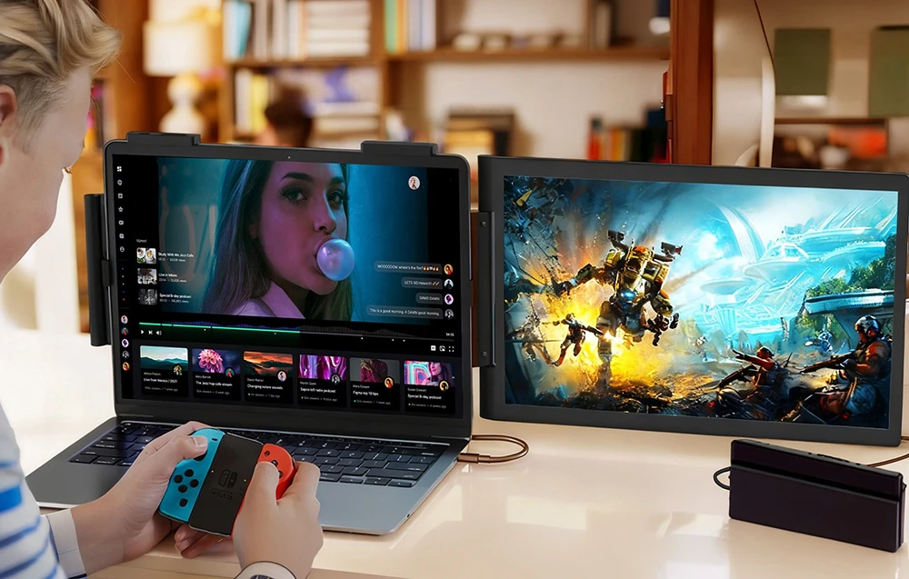 O persoană se joacă pe o consolă Nintendo Switch folosind un monitor suplimentar conectat la un laptop